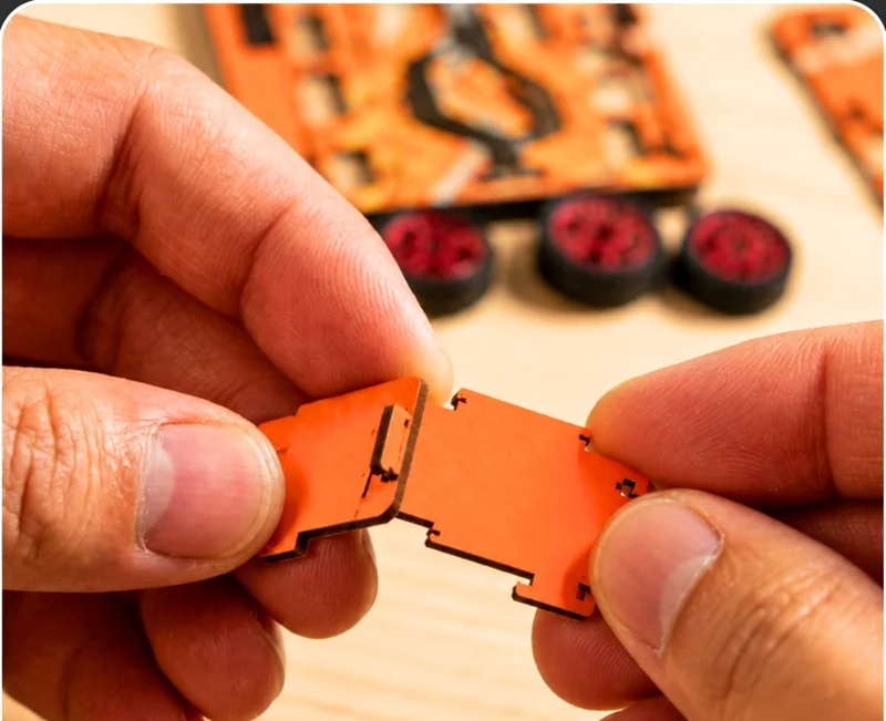 Hands fitting two laser-cut parts together